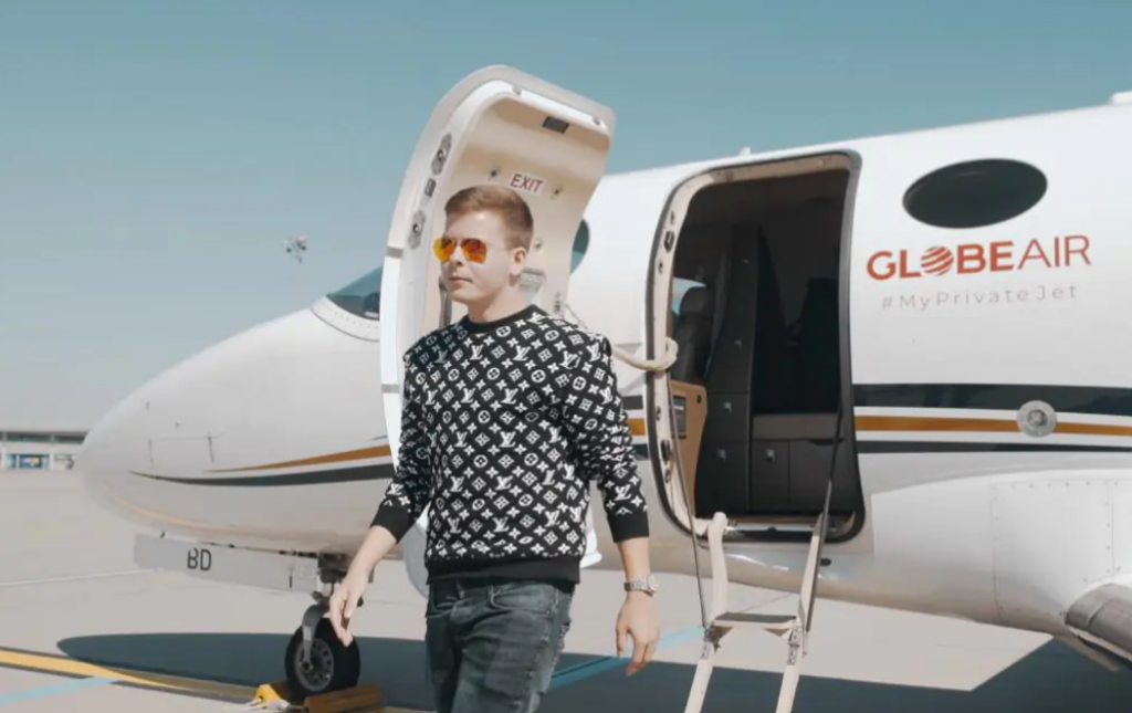 Jürgen Schroll mit Pullover in schwarz-weiß und Jeans steigt aus einem Globeair Privatjet