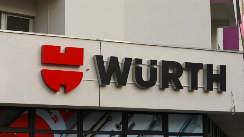 Logo von Würth in schwarz mit roten Symbolen auf einer Hausmauer über dem Eingang in eine Filiale