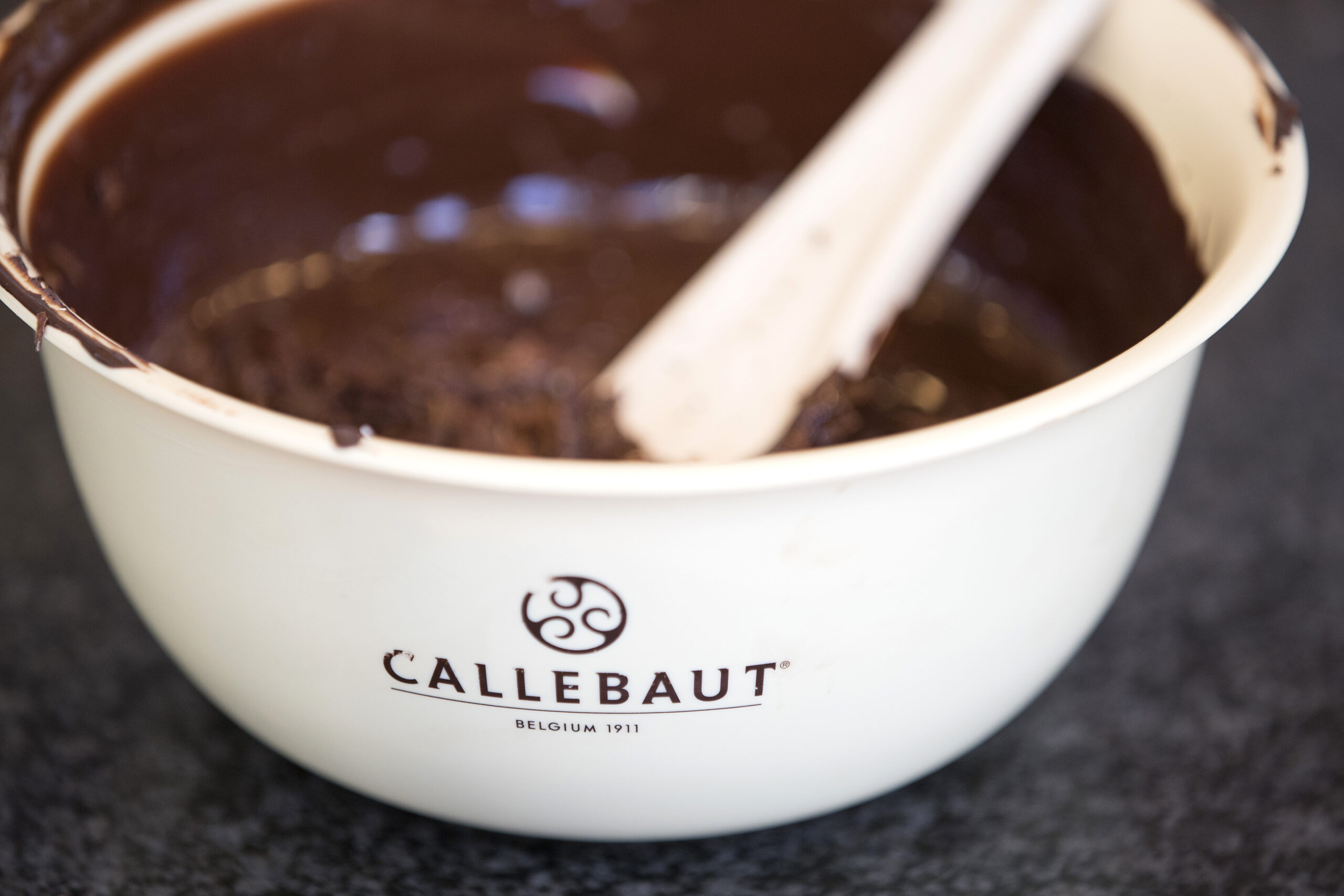 weiße Schüssel von Callebaut mit dunkler Schokolade gefüllt