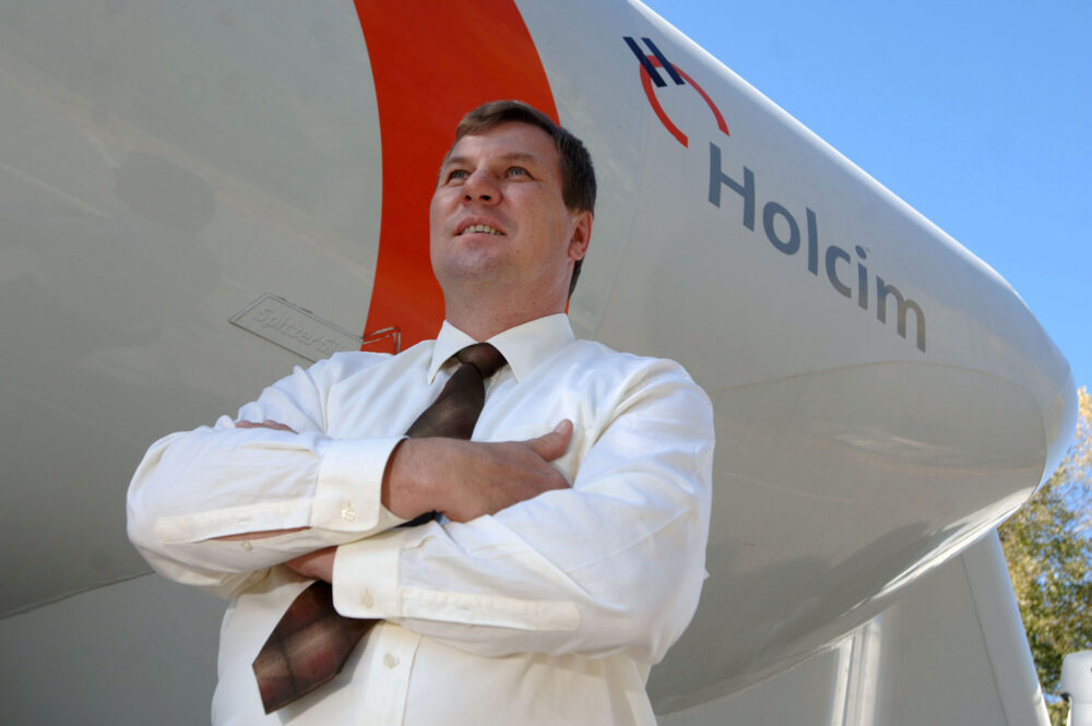 Logo von Holcim und dafür der CEO mit verschränkten Armen