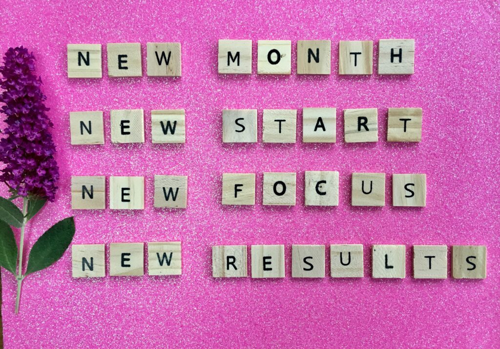 new month new start new focus new results auf rosarotem Hintergrund