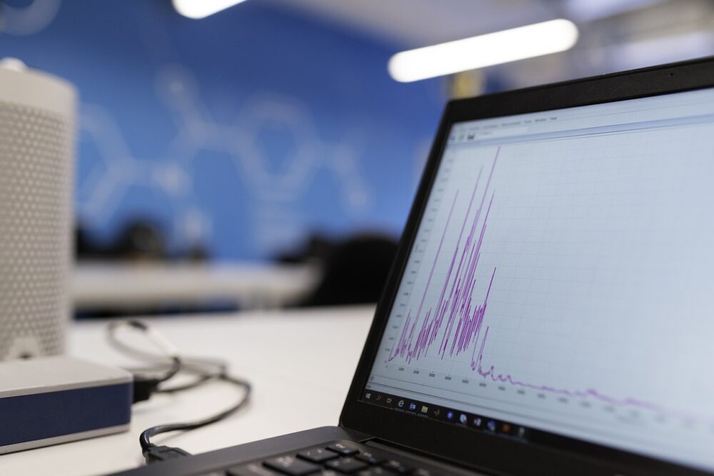 Schreibtisch mit Forschungsdiagrammen und Laptop symbolisiert die Partnerschaft von Digital Science und Sunmedia im Research-Reporting – Foto: This_is_Engineering / Pixabay