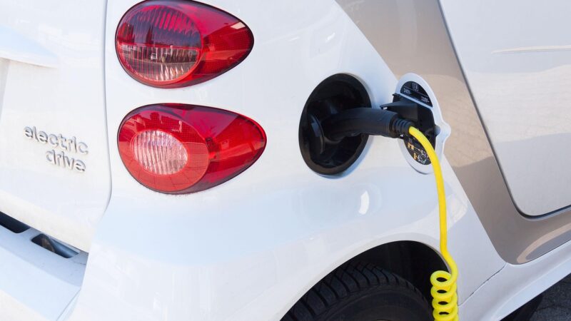 Ladekabel an einem Elektroauto auf einem Parkplatz, Symbolbild für den steigenden E-Auto Marktanteil in der EU – Foto: stux / Pixabay